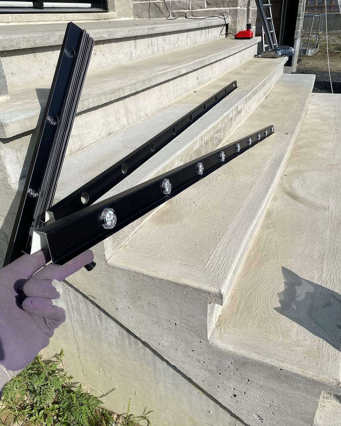Cut track lengths laid out on concrete steps before install