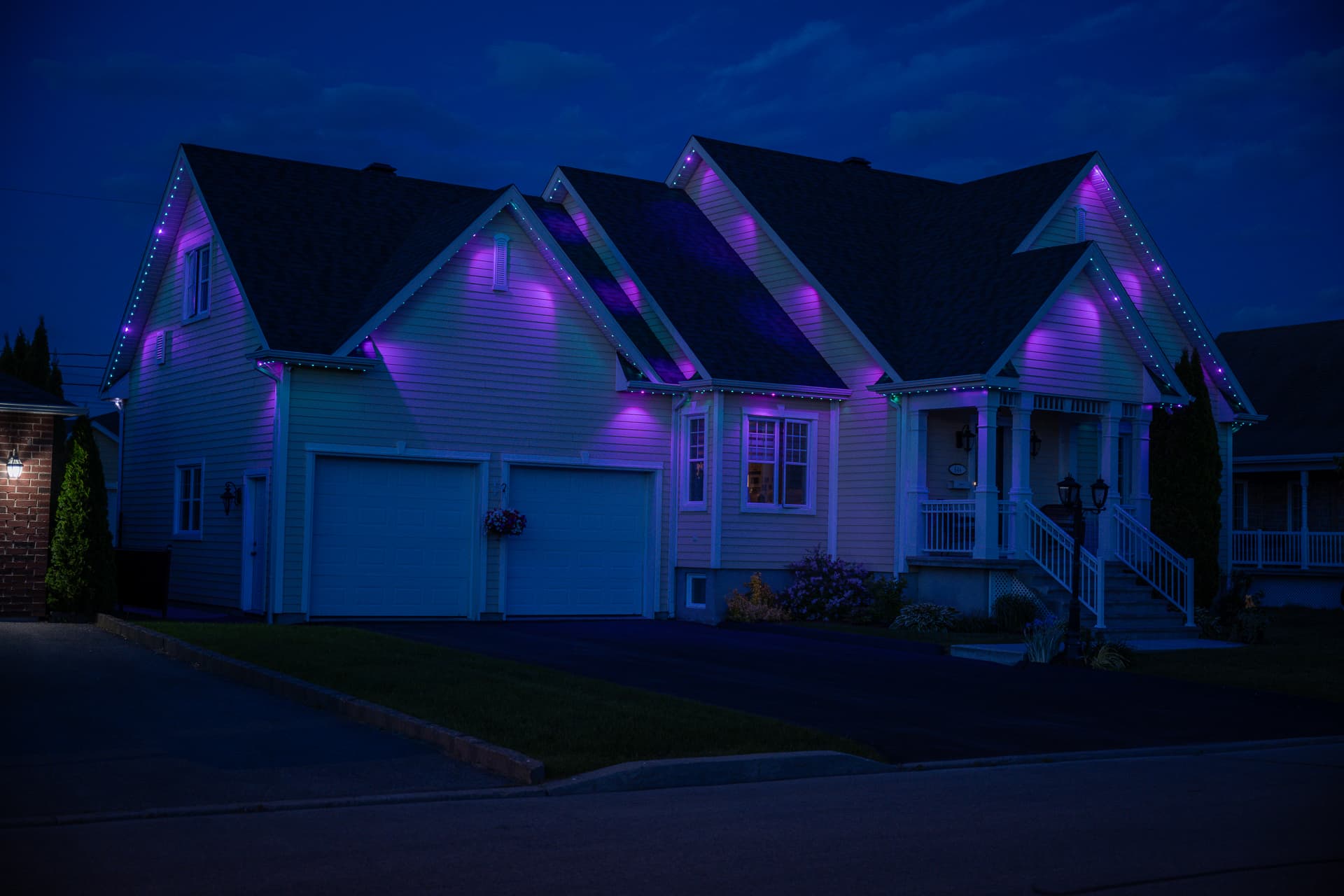 Home with blue and purple permanent roofline lighting