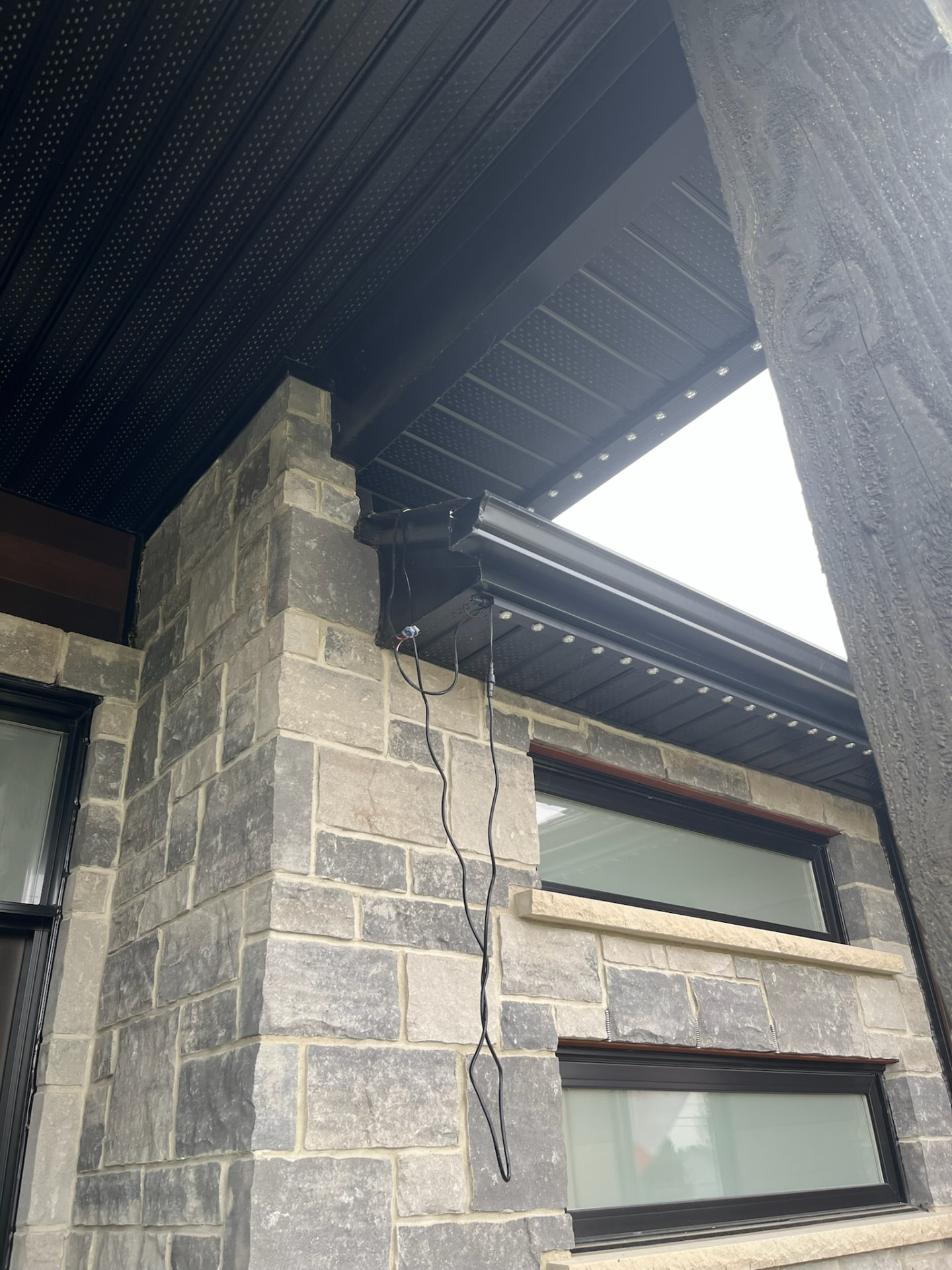 Wiring being connected under a black gutter during installation