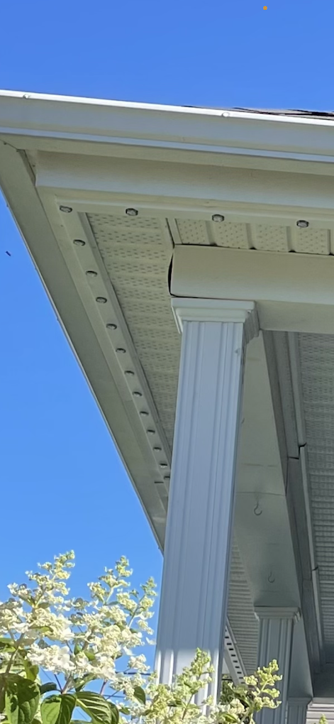 Close-up of permanent lighting track installed on a white soffit