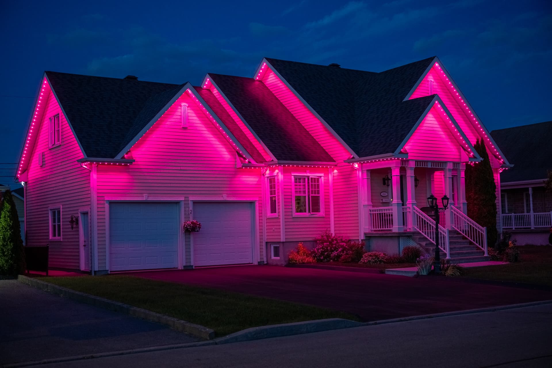 Home illuminated in a vivid pink permanent lighting scene