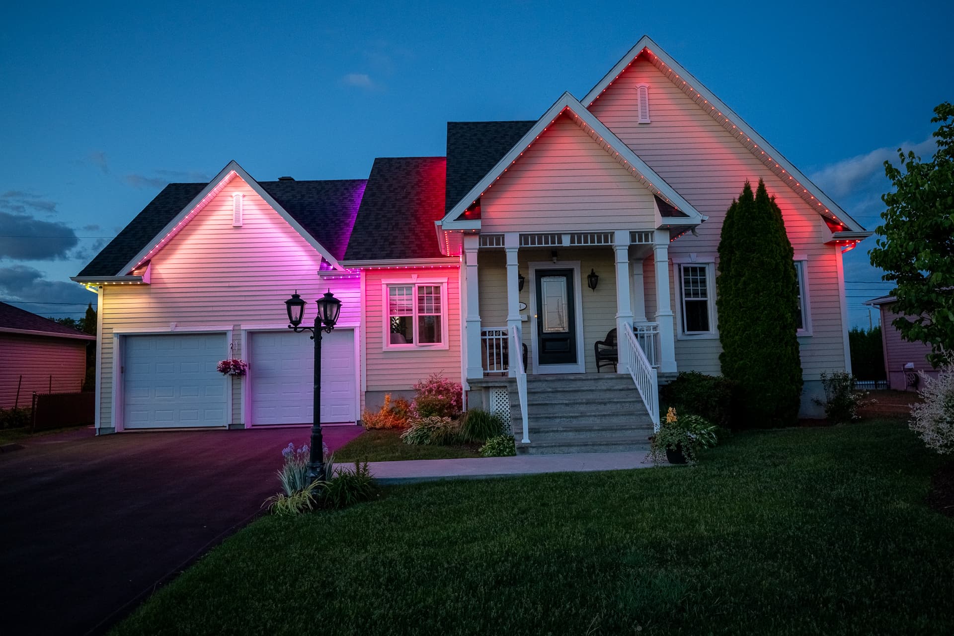 Home entry and roofline illuminated in pink and warm white