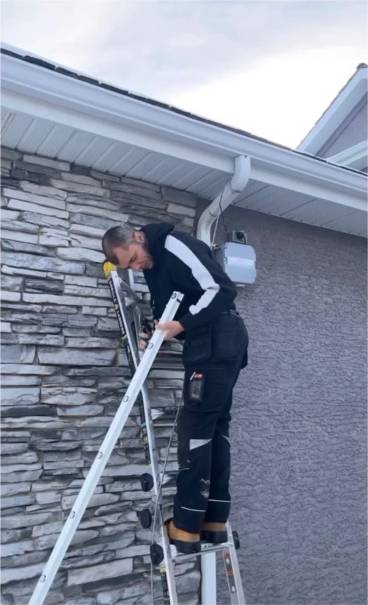 Installer on a ladder fitting roofline track