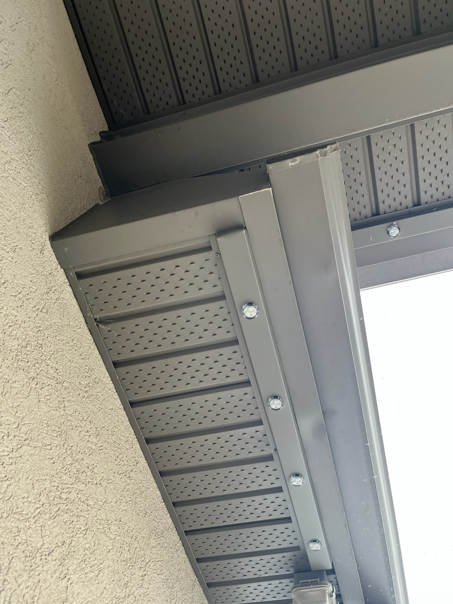 Grey permanent lighting track following a soffit corner